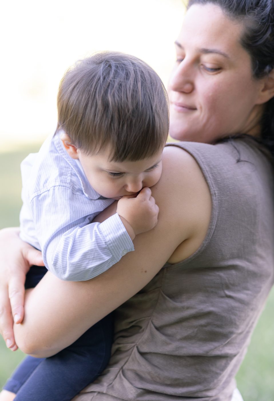 Ein kleiner Junge kuschelt sich an die Schulter seiner Mama